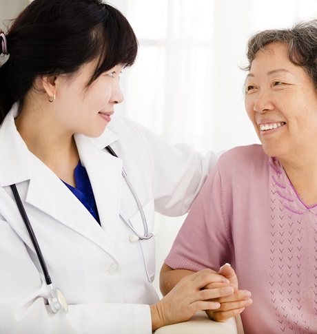 Nurse holding hand of an Asian senior woman